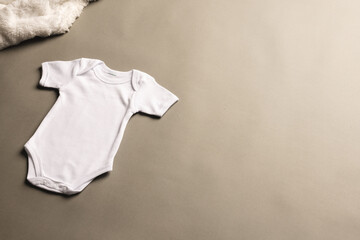 Flat lay of white baby grow with copy space on grey background