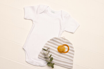 Flat lay of white baby grow, hat and dummy with copy space on white background