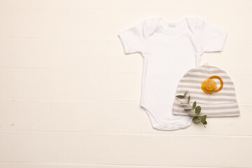 Flat lay of white baby grow, hat and dummy with copy space on white background