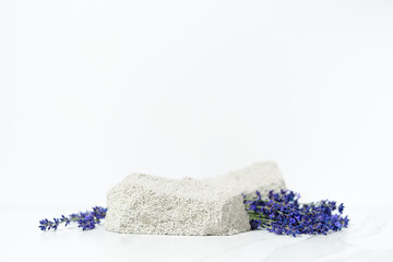 Product presentation scene template made with porous stone podium and lavender flowers on white background.
