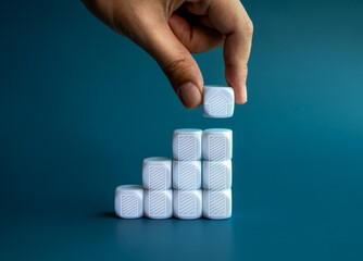 Business goal and success. Arrow head, drawing on white blocks, put by hand on top of growth graph...