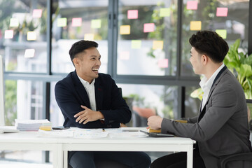 Two colleagues asian businessman working together to business finance trading at office desk.