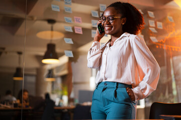 Happy businesswoman in office. Portrait of beautiful businesswoman using the phone. Woman talking to the phone.