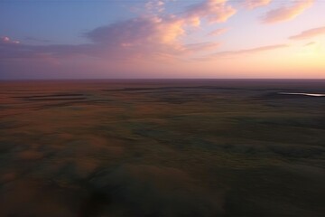 Fototapeta na wymiar Flight over the evening steppe in sunset colors.