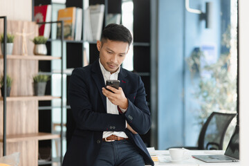 Asian businessman working with smartphone at office workplace. 