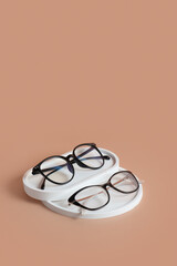Podiums with eyeglasses on colored background. Optical store, vision test, stylish glasses concept top view, flat lay
