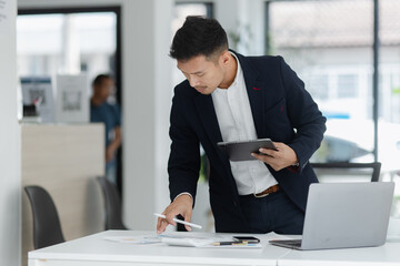 Portrait of candid happy asian businessman working in office.
