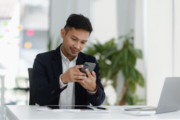 Portrait of candid happy asian businessman working in office.