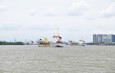 Fototapeta na wymiar SAMUT PRAKAN, THAILAND - August 3, 2023: A cargo ship is sailing through the Chao Phraya River at Thailand.