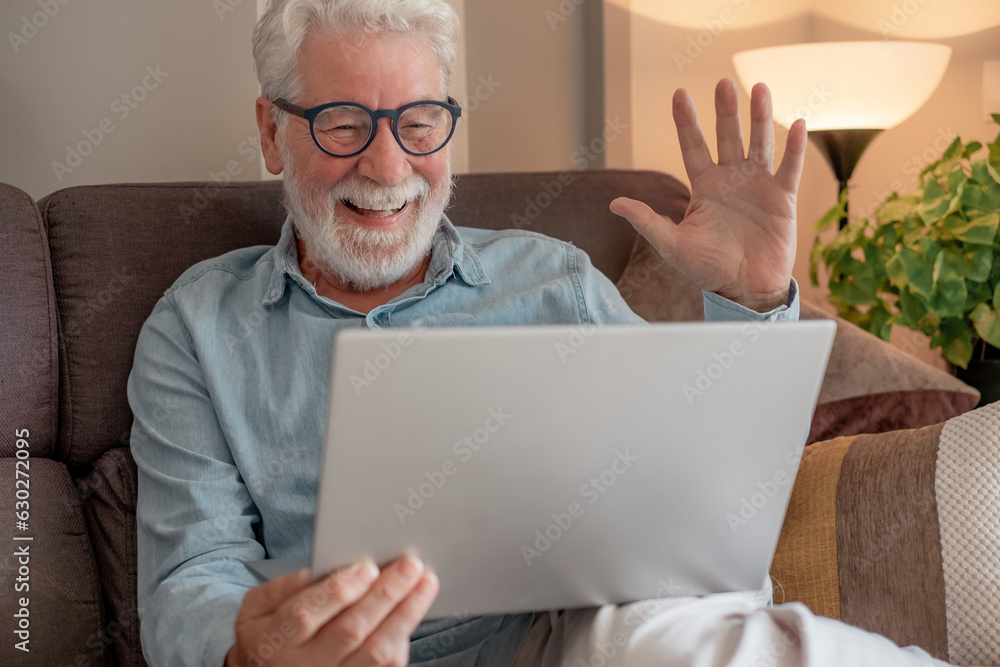 Sticker Video call concept. Happy senior bearded man laughing in video connection with family or friends waving hand. Old retired male using laptop sitting on sofa at home