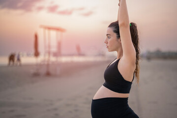 Pregnant women standing in fitness studio holding their bumps at the gym  from Pikwizard