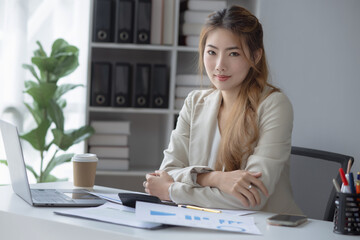Smiling Asian businesswoman executive manager sitting at desk in office, Portrait of attractive professional asian businesswoman.