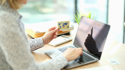 Woman shopping online and using laptop. Manager typing entering information and checking balance