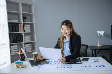 Asian businesswoman working with documents paper and laptop sitting at desk in office workplace, business finance and accounting, business online training concept.