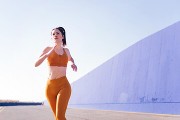 photo with motion of a caucasian sporty woman running in a athletic track, concept of sport and...