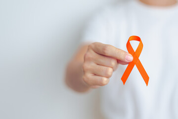 woman with Orange Ribbon for Leukemia, Kidney cancer day, world Multiple Sclerosis, CRPS, Self Injury Awareness month. Healthcare and word cancer day concept