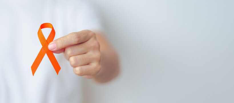 woman with Orange Ribbon for Leukemia, Kidney cancer day, world Multiple Sclerosis, CRPS, Self Injury Awareness month. Healthcare and word cancer day concept