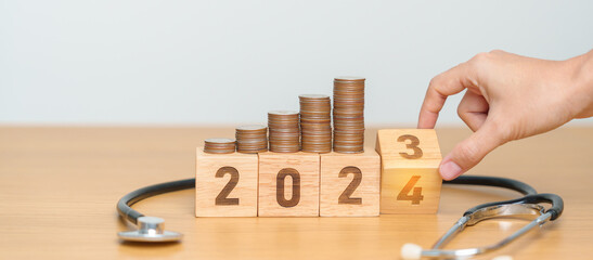 2024 Happy New Year for health care with doctor Stethoscope on table. Money saving, Goal,...