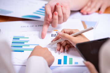 People's hands working with papers at meeting discussions shows successful teamwork.