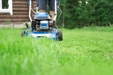 Lawn mower cutting grass. Small grass cuttings fly out of lawnmower. Grass clippings get spewed out...