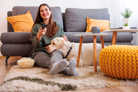 Woman and dog watching TV at home