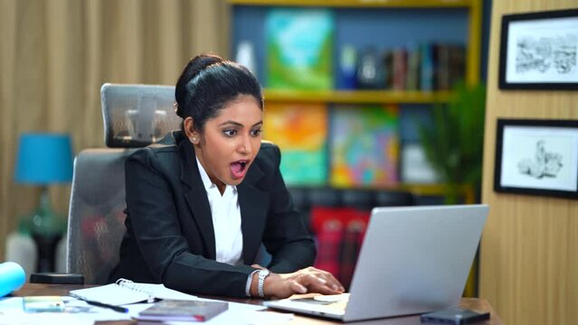 The working woman in the office is overjoyed and elated, witnessing positive results on her screen. Her hard work and dedication have paid off, bringing a smile to her face.