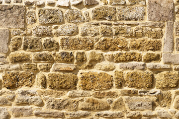 The texture of the old medieval wall of the house, lined with brown stone