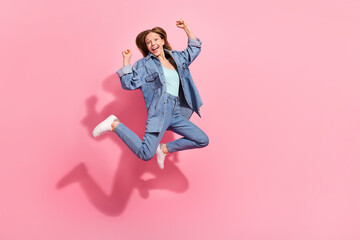 Full length photo of overjoyed stylish girl raise fist hands celebrate succes run empty space isolated on pink color background