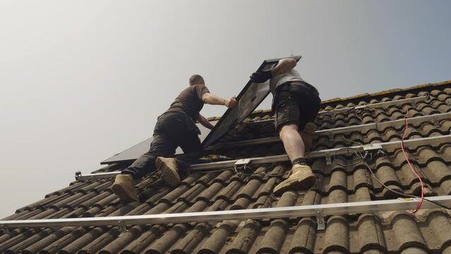 MS LA Technicians fitting solar photo voltaic panels to house roof