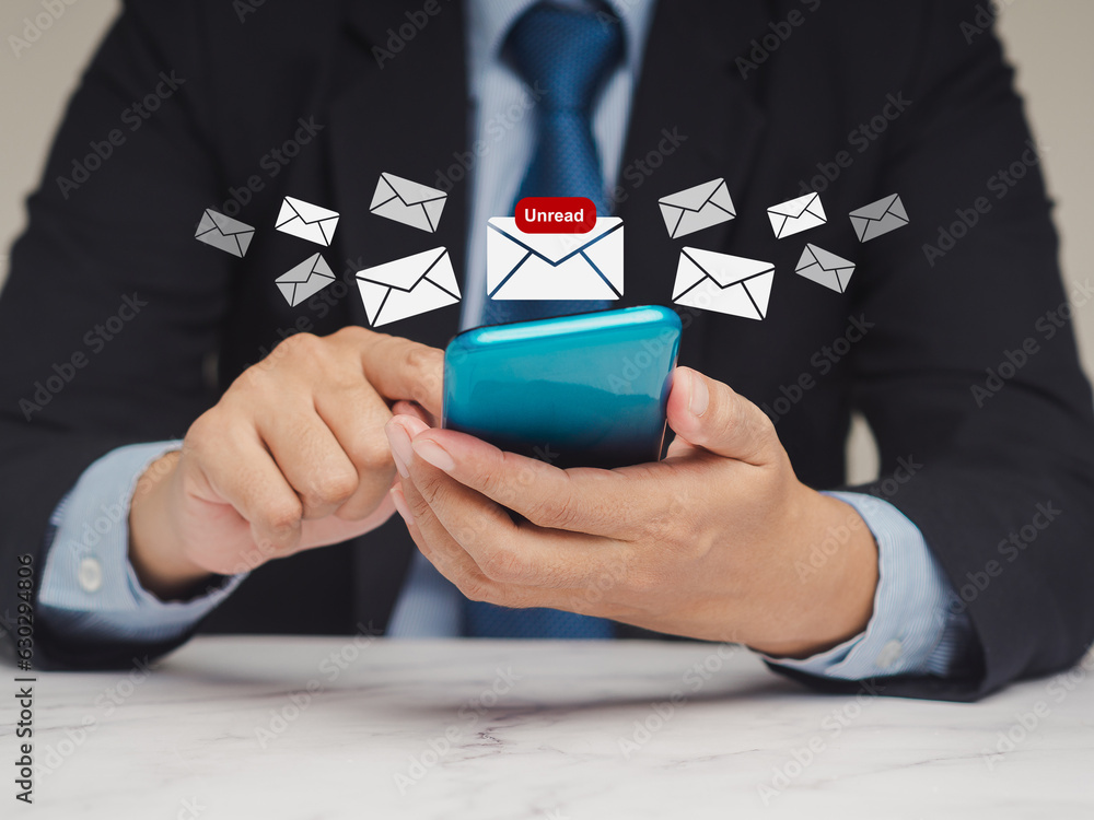 Poster businessman using a smartphone receives a new message with email icons while sitting at the table