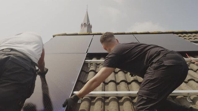 MS Technicians fitting solar photo voltaic panels to house roof