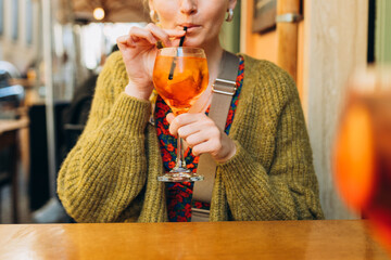 Happy 30s girl sitting on the cafe terrace on the city street. Traveler. Woman hands toasting with...