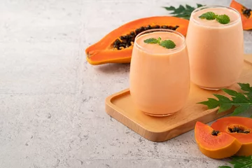 Foto auf Acrylglas Delicious papaya milk smoothie in glass cup on gray table background © RomixImage