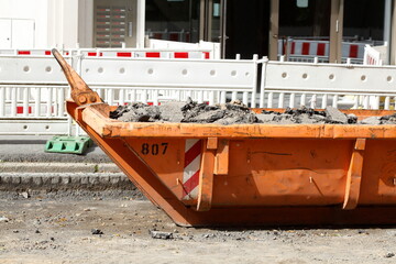 Container, orange Absetzmulde für Bauschutt auf der Straße stehend, Baustelle, Deutschland