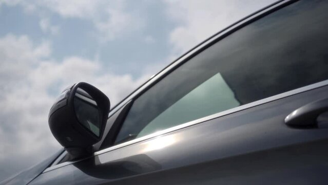 Сar reflects the sun's rays outdoors. The concept of buying a new car. Parking near the car dealership under the open sky.