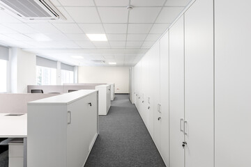 An office with a lot of lockable filing cabinets. Shrinking perspective. Selective focus.
