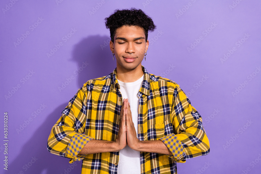 Sticker Photo of excited praying guy dressed checkered yellow shirt closed eyes pleading god isolated purple color background