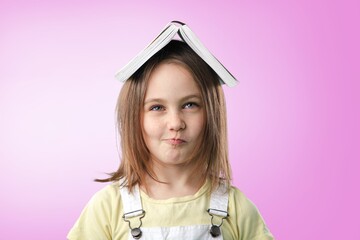 Adorable smiling school student holding book