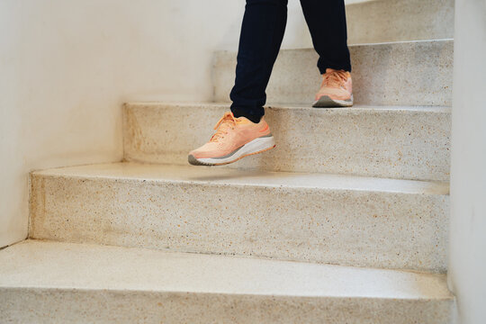 Going downstairs. Close up view of woman legs walking downstairs.