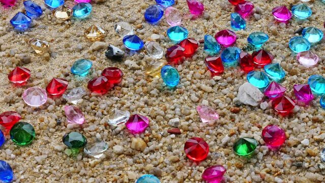 Colorful diamonds scattered on the beach The sun glistened off the facets of the precious stones, .creating a beautiful contrast with the white sand.colorful gemstones on the beach ..