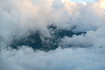 Cloudy mountains.
Mountains in clouds at sunrise in summer. Aerial view of mountain peak with green trees in fog. Top view of mountain valley in low clouds from drone. Rize Huser plateau, T&uuml;rkiye