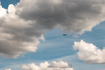 Commercial airplane between clouds. passaner plane flies on the sky framed by cumulus clouds.