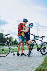 Fototapeta na wymiar a guy and a girl in cycling helmets and glasses are hugging holding bikes