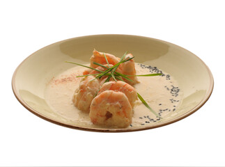 Pre-marinated shrimp in fragrant ginger and Garam Masala, fried in white wine with cream in a light plate on a white background, restaurant dish.