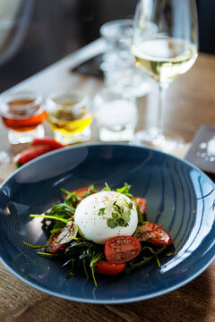 Burrata with paprika-truffle jam and cherry-cluster tomato salad. Delicious healthy Italian traditional food closeup served for lunch in modern gourmet cuisine restaurant