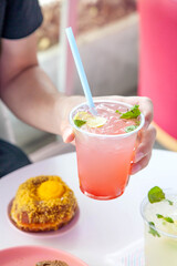 Iced mocktails in a plastic cup in a restaurant environment.