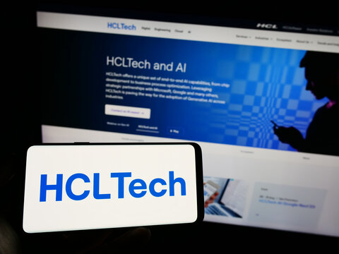 Stuttgart, Germany - 07-28-2023: Person holding celphone with logo of Indian company HCL Technologies Limited on screen in front of business webpage. Focus on phone display.
