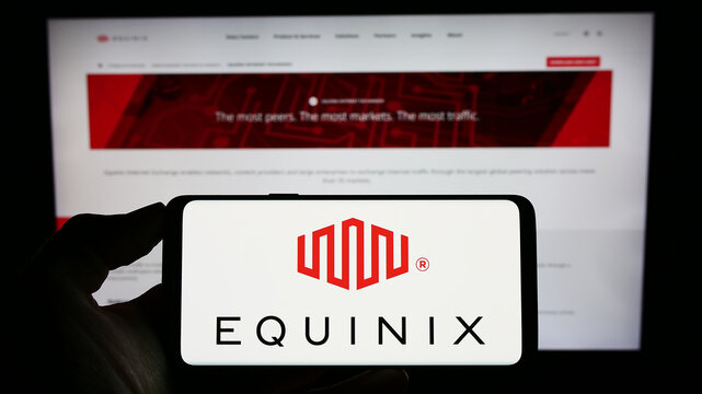 Stuttgart, Germany - 07-28-2023: Person holding cellphone with logo of US data center company Equinix Inc. on screen in front of business webpage. Focus on phone display.
