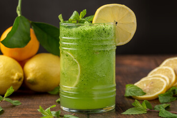 Lemonade with ice and mint in glass glass on wooden table