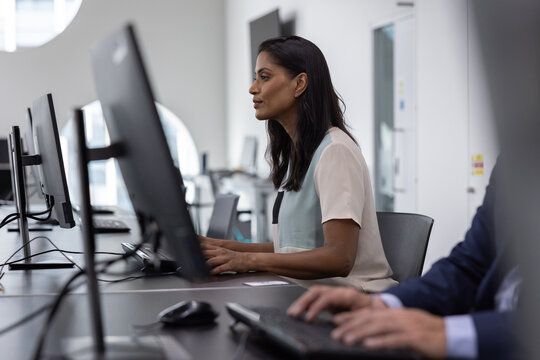 Businesswoman working in an office on a desktop computer